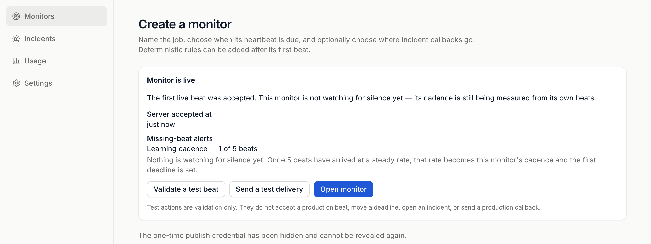 The Monitor is live receipt after the first beat: server accepted it just now, missing-beat alerts are learning the cadence at 1 of 5 beats, with Validate a test beat, Send a test delivery and Open monitor buttons, and a note that the one-time publish credential has been hidden